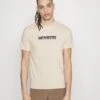 Calvin Klein New York Box Logo - Print T-Shirt - Stony Beige 1 Calvin Klein New York Box Logo - Print T-Shirt - Stony Beige -Stock X b087c0aad4c54b4fa35b52dd491515bb