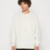 Calvin Klein Jeans Embro Neck Crewneck Unisex - Sweatshirt - Eggshell -Stock X eeef1e10b1a64ffcad370ceec56f9152